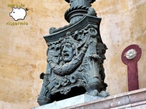 Basamento in bronzo finemente scolpito di un monumentale candelabro del Teatro Massimo di Palermo, decorato con mascheroni teatrali espressivi, festoni e rilievi classici
