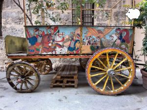 Carretto siciliano in legno finemente decorato con dipinti di cavalieri medievali e scene cavalleresche