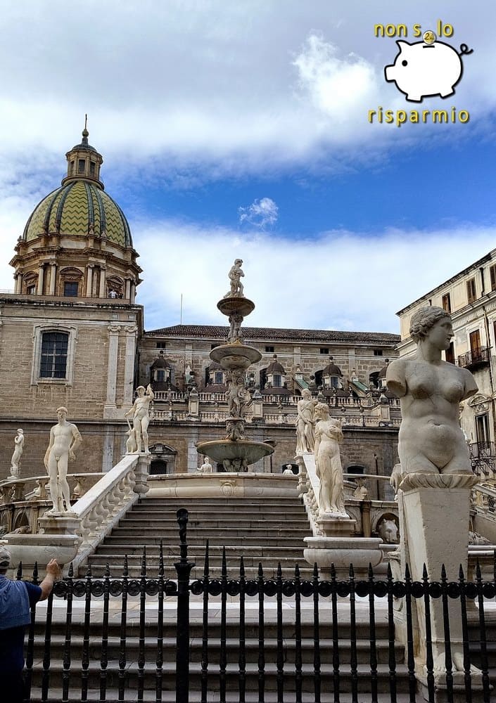 Scorcio della monumentale Fontana Pretoria a Palermo con le sue statue di marmo nudo, le gradinate e la cupola della Chiesa di San Giuseppe dei Teatini sullo sfondo