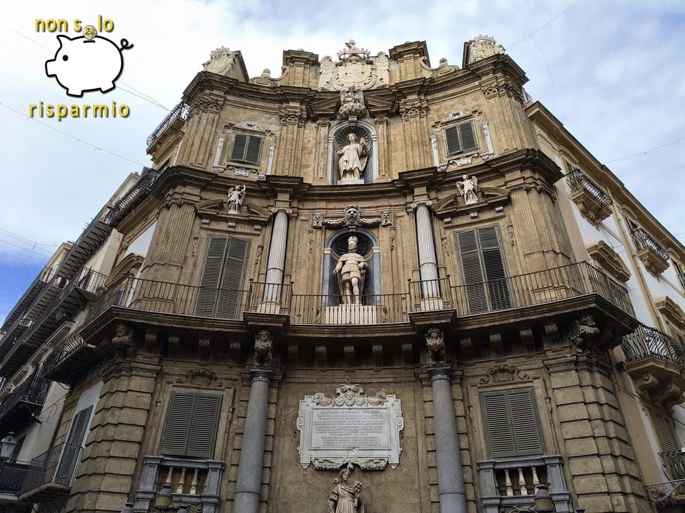 Scorcio angolare dal basso della facciata concava del canto di Filippo III ai Quattro Canti di Palermo, con balconate, nicchie scultoree e targa in latino.