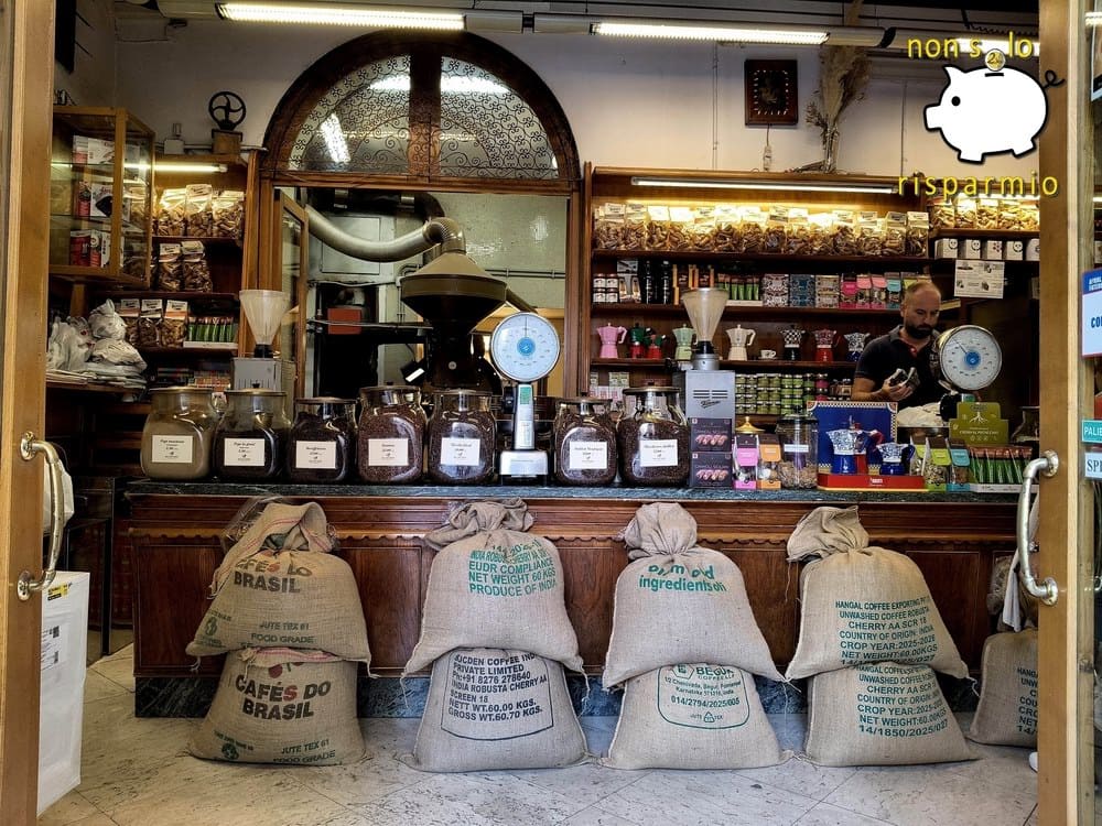 Torrefazione Stagnitta di Palermo: Interno di una storica torrefazione artigianale con sacchi di iuta pieni di chicchi di caffè in grani disposti davanti al banco in legno, vasetti in vetro contenenti miscele, bilance d'epoca e macchinari per la tostatura sullo sfondo